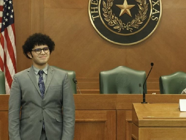 student with winning smile dressed in a suit