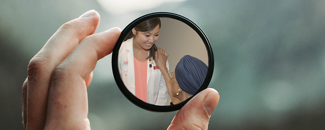 hand holding magnifying glass focused on student and patient 